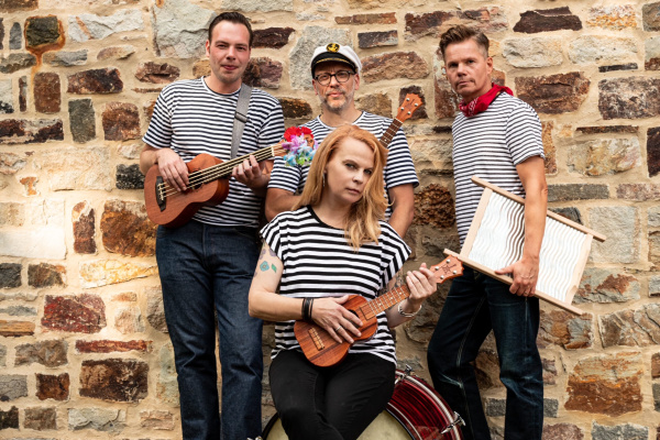 Vier Musiker mit ihren Insztrumenten in gestreiften Oberteilen vor einer Wand