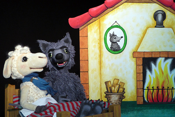 Ein Schaf und ein Wolf sitzen auf einem Bett