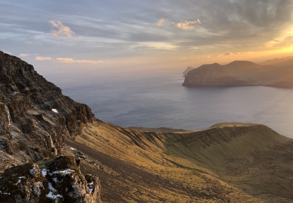 Blick bei Sonnenuntergang über Berge am Meer