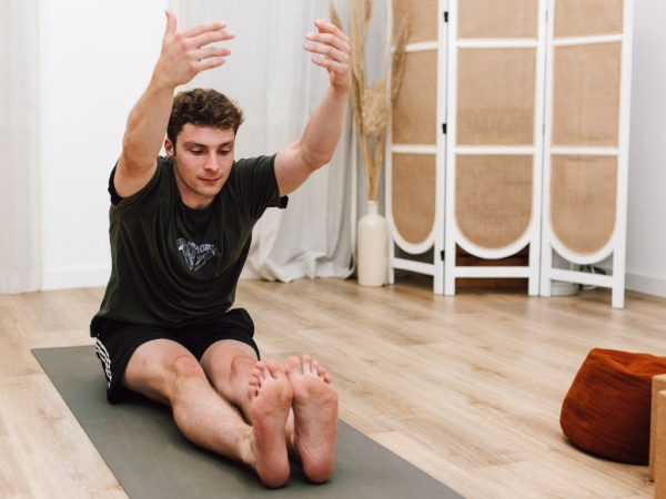 Ein sich dehnender Mann in einer sitzenden Vorbeuge