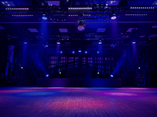 Das Bild zeit eine bunt beleuchtete Tanzfläche und Bühne.